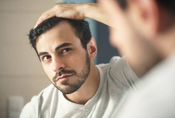 a man checking his receding hairline